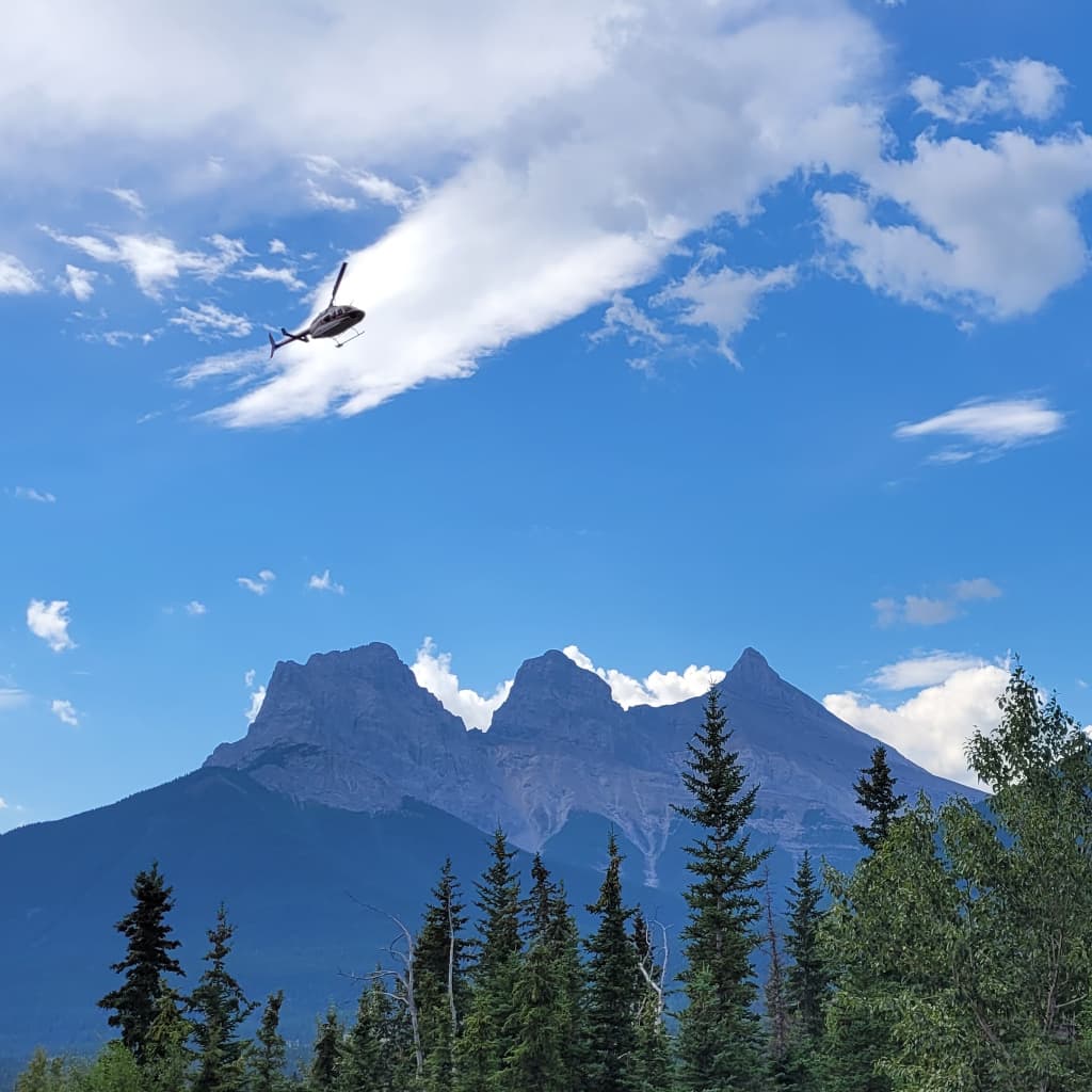 Helicopter flying over the Three Sisters, Canmore
