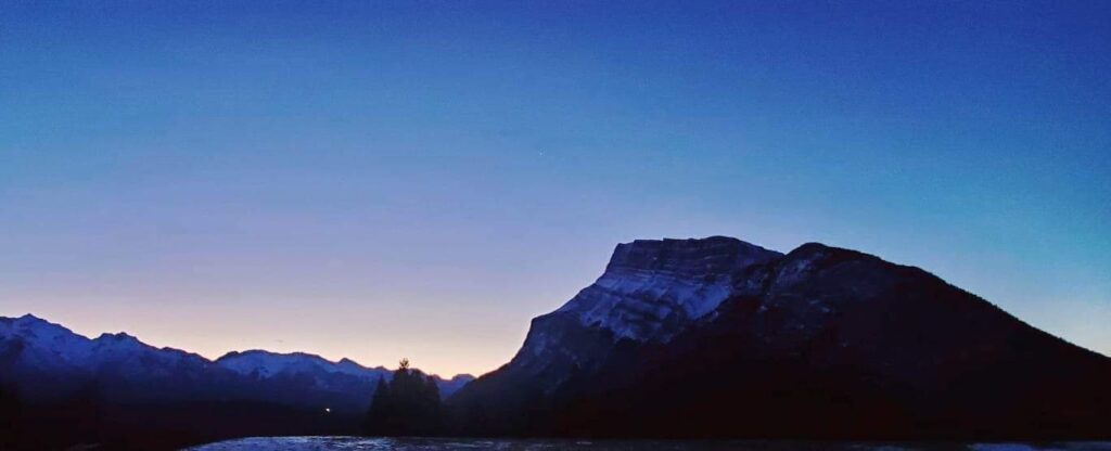 sunrise over the mountains at Tunnel Mountain reservoir in Banff