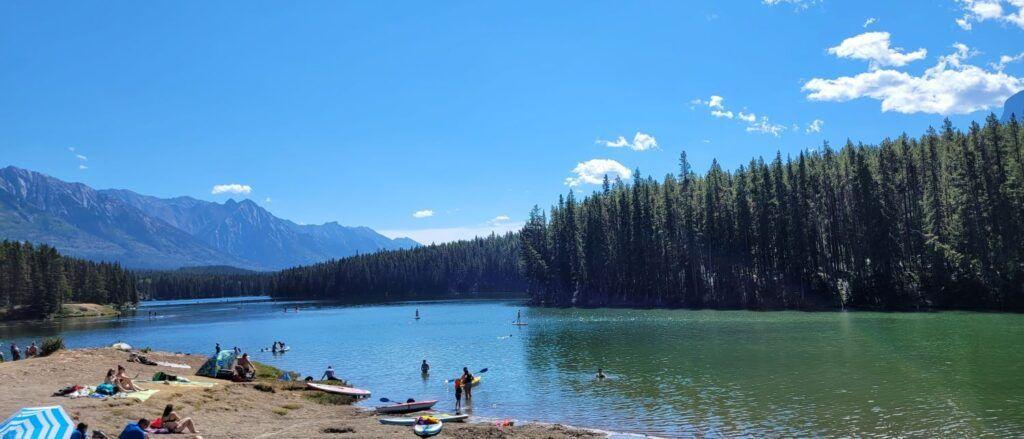 Johnson Lake in summer with beach area and people canoeing and kayaking